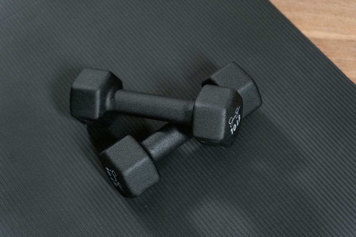 A simple beginner home workout setup with light weights and a mat