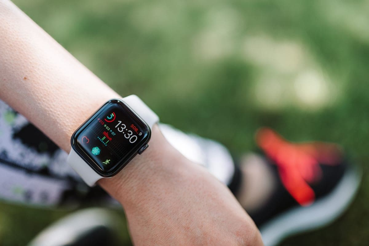 A fitness smartwatch resting on a table showing workout metrics