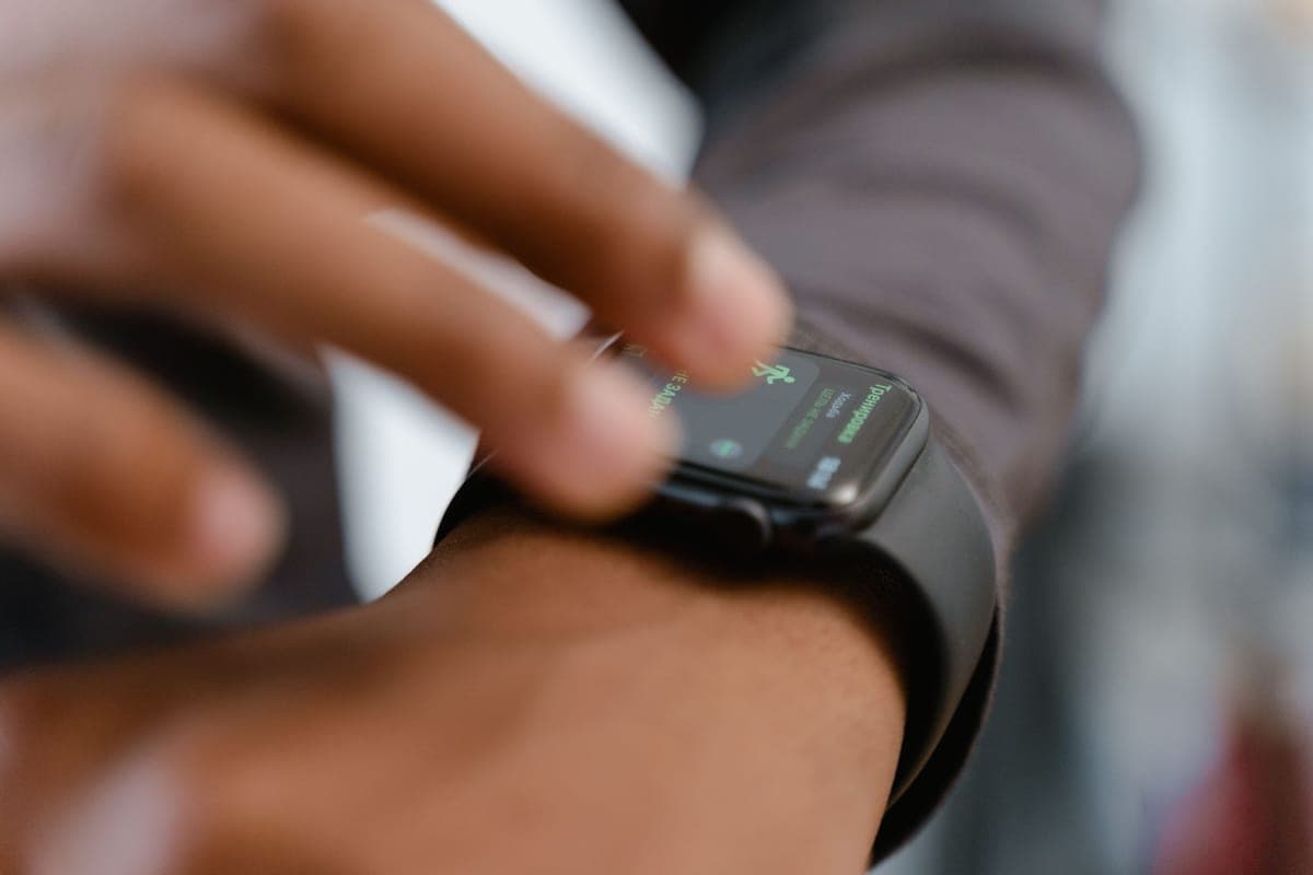 A fitness smartwatch on a wrist showing heart-rate data mid-workout
